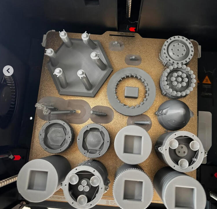 Díly modelu rakety na tiskové podložce v 3Djust4U